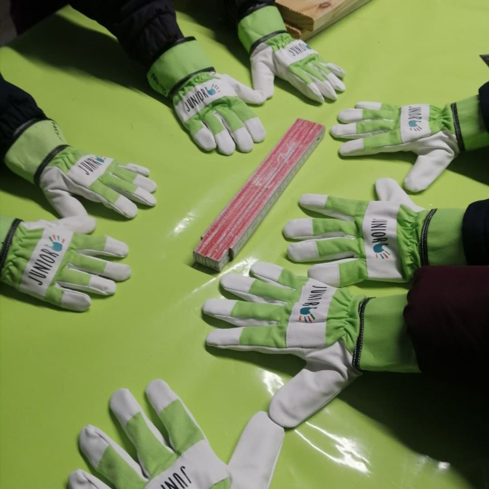 Arbeiter Handschuhe die um einen Meterstab herum sind